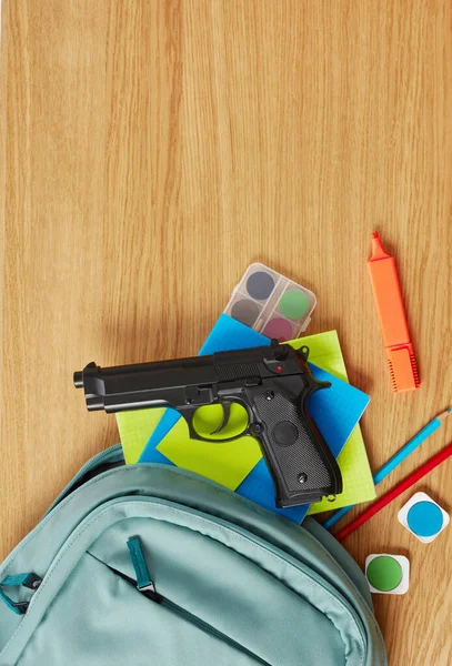 Backpack, school supplies and gun — Stock Photo, Image