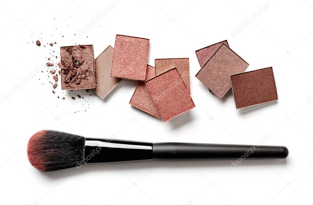 Brown face powders and makeup brush on white background