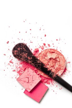 Ezilmiş makyaj tozları ve beyaz arka planda fırça