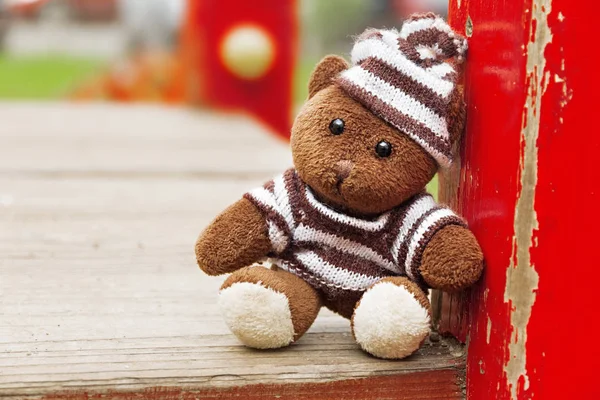 Soft toy bear sitting on the playground