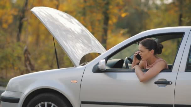 Mujer en un coche roto hablando por teléfono — Vídeos de Stock