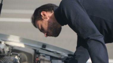 Kırık bir araba tamir etmeye çalıştığını adam