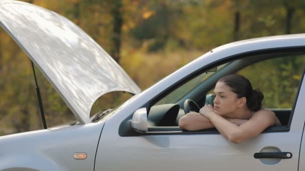 Traurige junge Frau in kaputtem Auto — Stockvideo