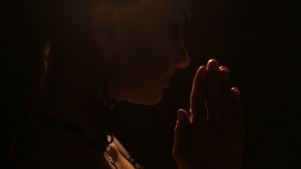 Mujer rezando en la oscuridad — Vídeo de stock