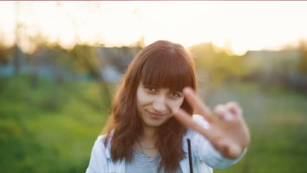 Femme montrant un signe de paix au coucher du soleil — Video