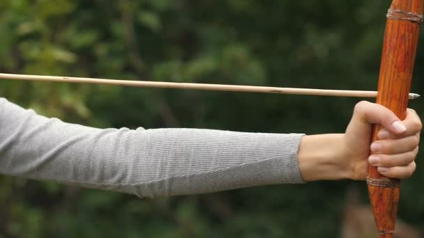 Женщина стреляет стрелой и удовлетворена результатом — стоковое видео