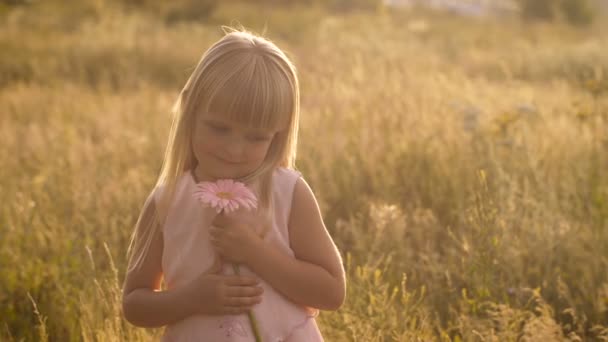 Niña con una flor en la naturaleza — Vídeo de stock