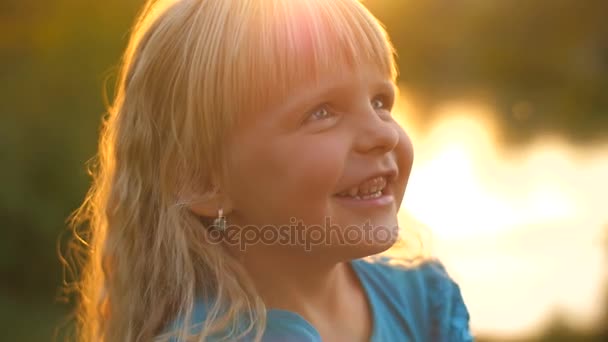 Το κορίτσι κοιτάζοντας μέσα από ένα μεγεθυντικό φακό στο ηλιοβασίλεμα — Αρχείο Βίντεο