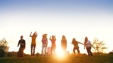 İnsanlar gün batımında atlama