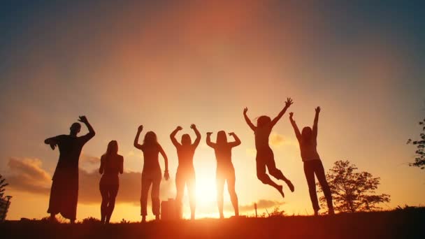 Pessoas alegres pulando ao pôr do sol — Vídeo de Stock