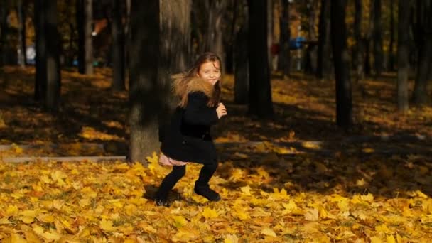 Sonriente niña corre en el parque de otoño — Vídeos de Stock