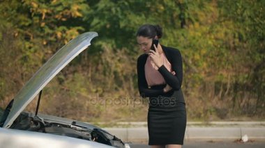 Arabası bozulmuş bir kadın telefonla arıyor.