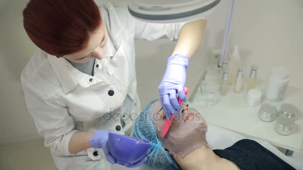 Cosmetologist εφαρμογή καλλυντικών μάσκα στο πρόσωπο — Αρχείο Βίντεο