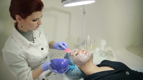 Esthéticienne appliquant un masque cosmétique sur le visage — Video