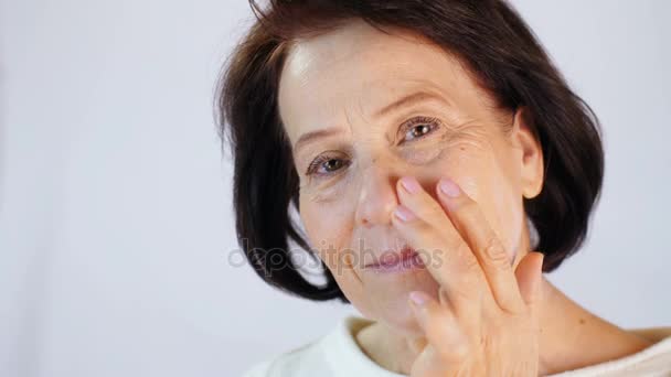 Mujer de mediana edad aplicando crema — Vídeo de stock