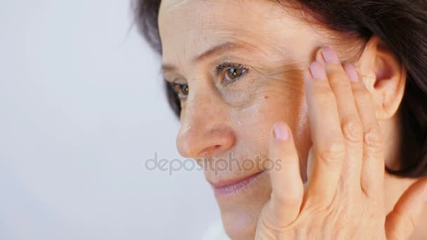 Mujer madura aplicando crema — Vídeo de stock