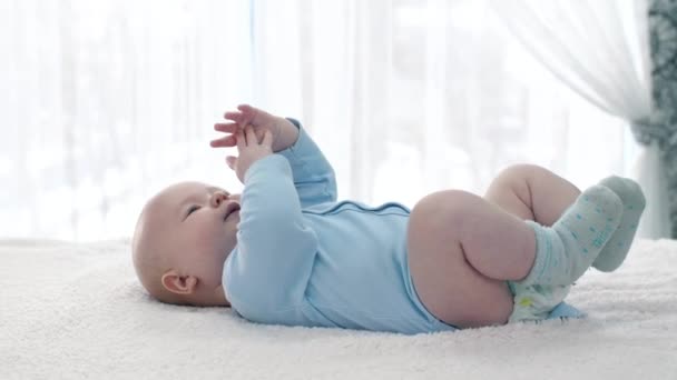 Pequeño bebé acostado en una espalda — Vídeos de Stock