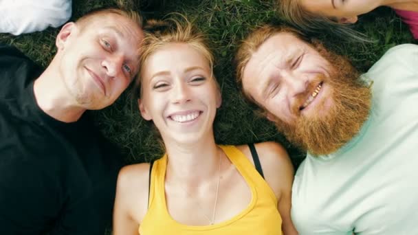 Des amis heureux allongés sur l'herbe — Video