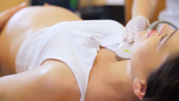 Беременная женщина делает УЗИ щитовидной железы — стоковое видео