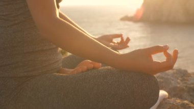 Kadın gün batımında zen gibi meditasyon yapar.