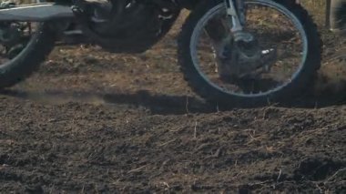 Motorcuların tekerleğinin altından toprak uçar.