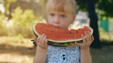 Doğada karpuz yiyen küçük kız