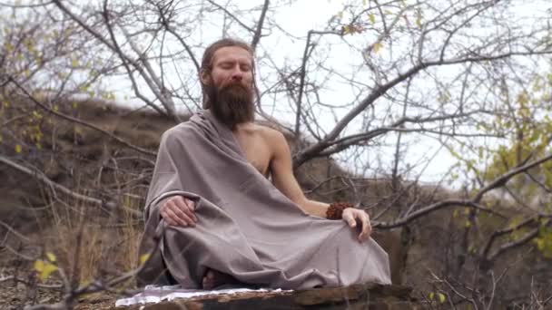 Аскетический йог сидит в медитации — стоковое видео