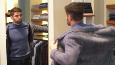 Delikanlı mağazada kıyafet deniyor.