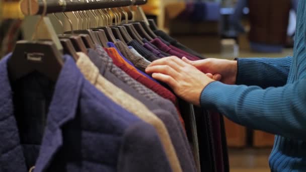Mann wählt Kleidung im Bekleidungsgeschäft — Stockvideo