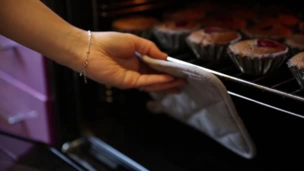 Kvinnan tar muffins ur ugnen — Stockvideo