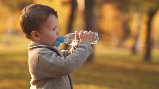 Маленький мальчик пьет воду — стоковое видео