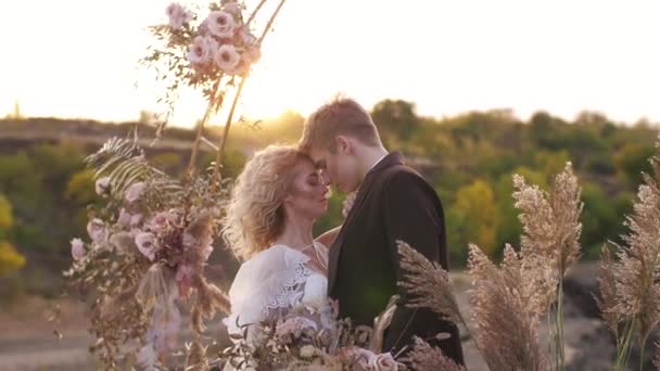 Pareja de boda bajo arco de boda — Vídeos de Stock