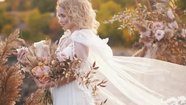 Невеста с цветами под свадебной аркой — стоковое видео