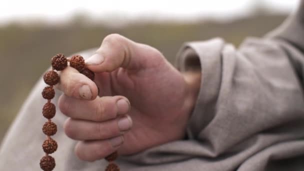 Homem meditando com contas sobre a natureza — Vídeo de Stock