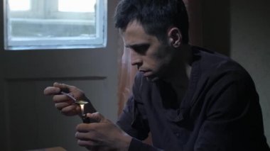 Adam eroini kaşıkta çakmakla ısıtıyor.