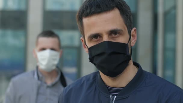Homens são máscaras protetoras na rua — Vídeo de Stock