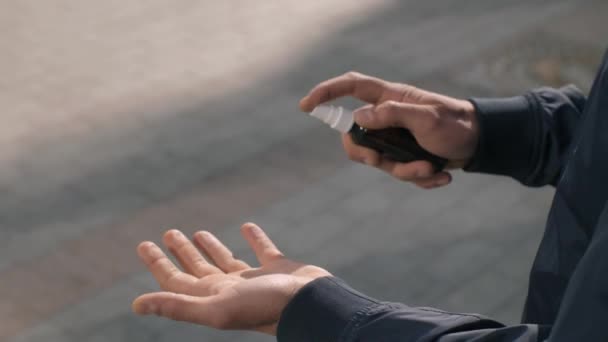 Mann setzt Antiseptikum auf der Straße ein — Stockvideo