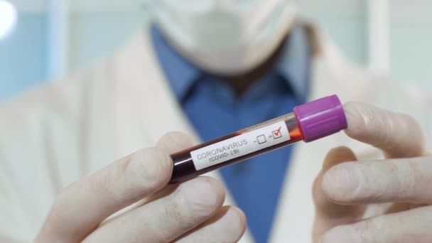 Концепція коронавірусу. Лікар тримає трубку з кров'ю . — стокове відео