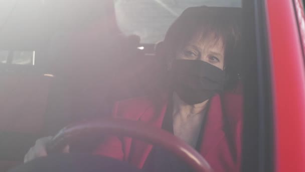 Droevige vrouw in het gezicht masker in de auto — Stockvideo