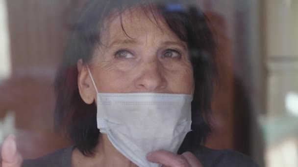 Пожилая женщина снимает маску для лица — стоковое видео