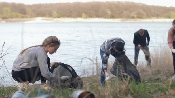 Gente recogiendo basura cerca del lago — Vídeos de Stock