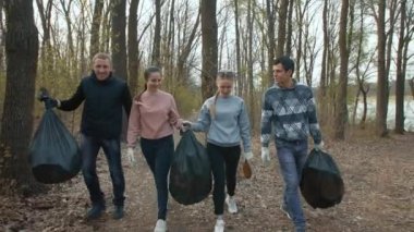 Çöp torbalı arkadaşlar parkta yürürler.