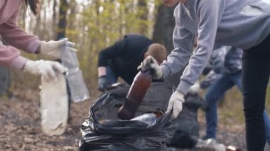Kadınlar poşete plastik çöp koyuyorlar.