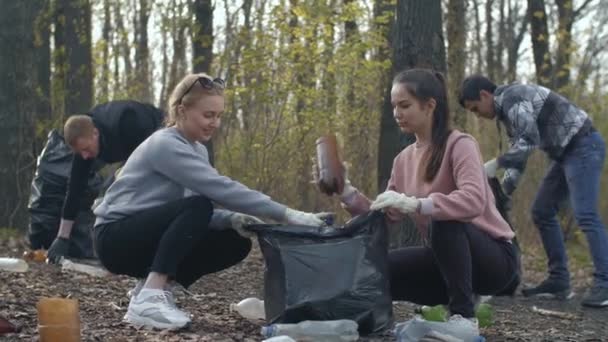 Счастливые люди собирают мусор в парке — стоковое видео