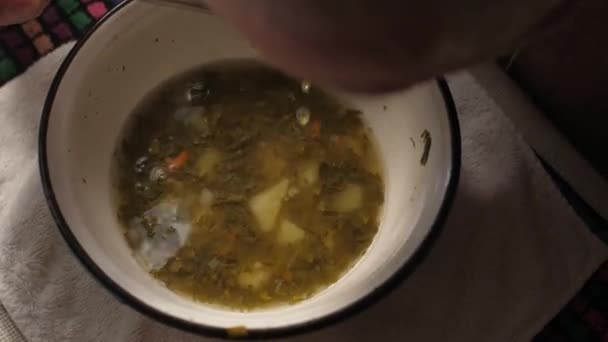 Poor man eating soup from metal plate — Stock Video
