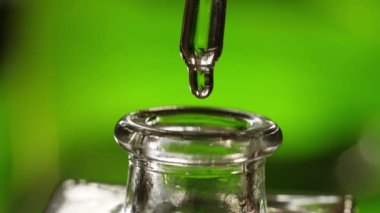 Pipetten şişeye yağ damlıyor.