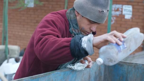 Homeless man in the trash looking for food — Stock Video