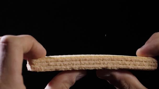 Le dita di uomo tengono un wafer e poi lo rompono a metà — Video Stock