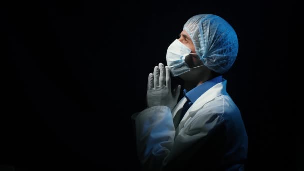 Doctor rezando en el cuarto oscuro — Vídeo de stock