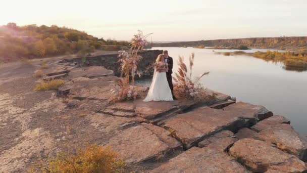 Mariée et marié étreignant au coucher du soleil — Video